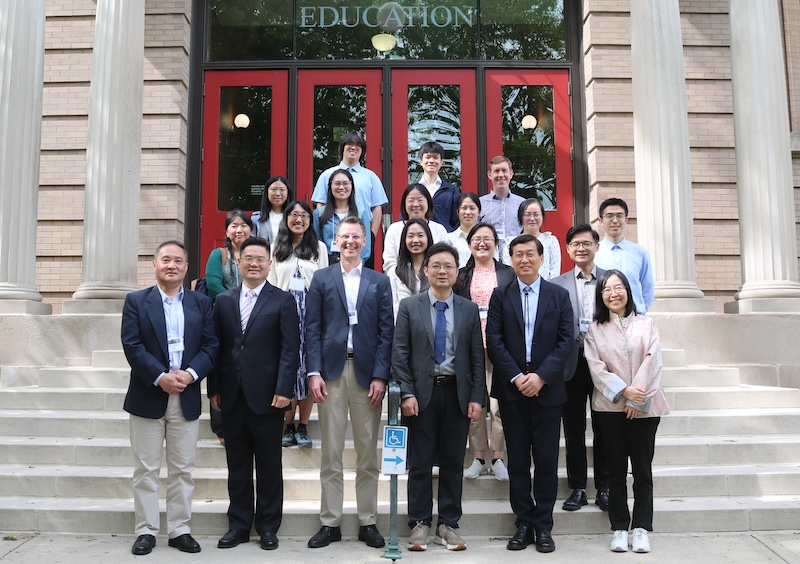 Some participants from this spring’s UW-PKU Workshop on Higher Education pose for a photo in front of the red doors of the Education Building on the UW–Madison campus.